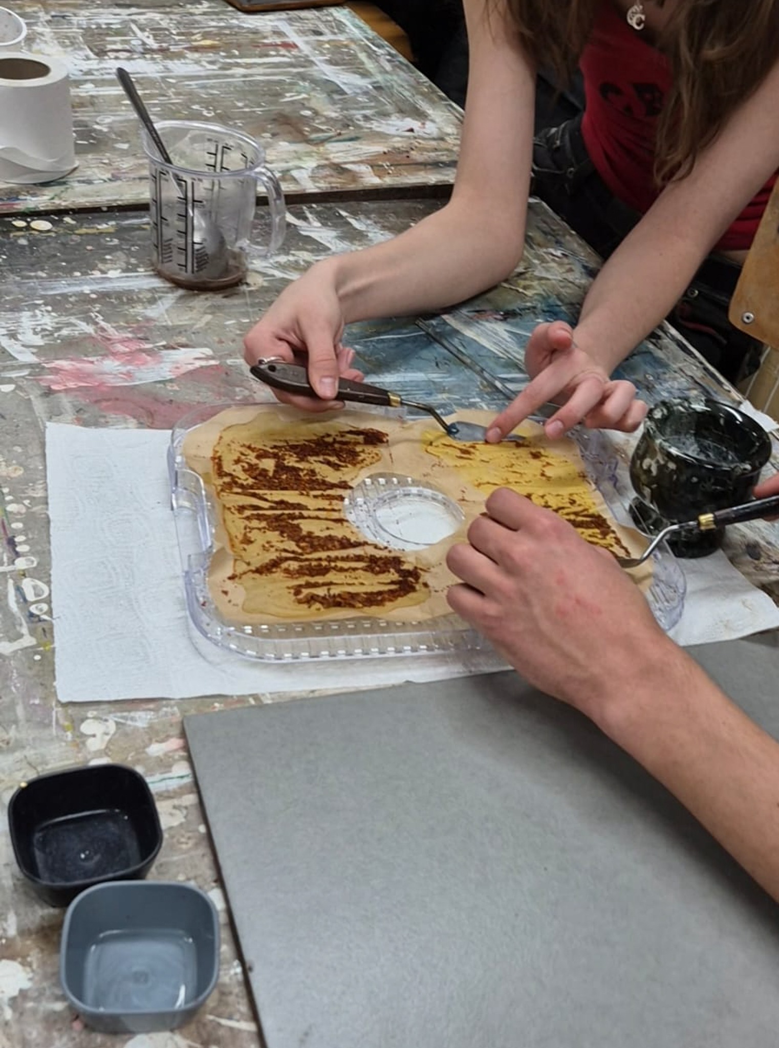 Participants preparing paint from pigment