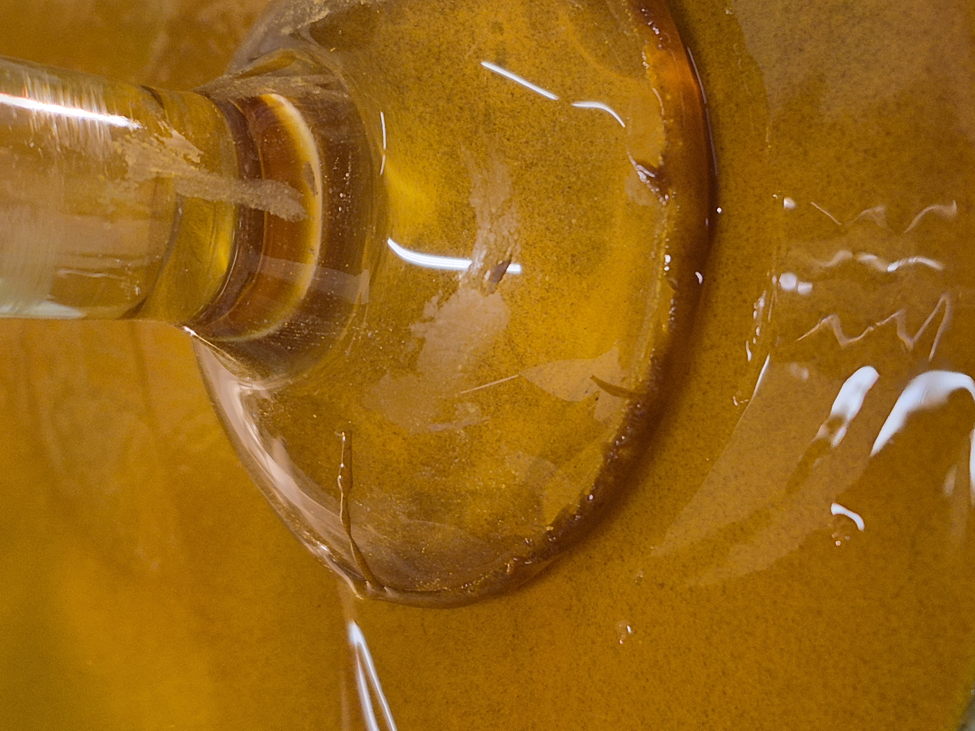 Golden pigment sediment forming around a glass vessel